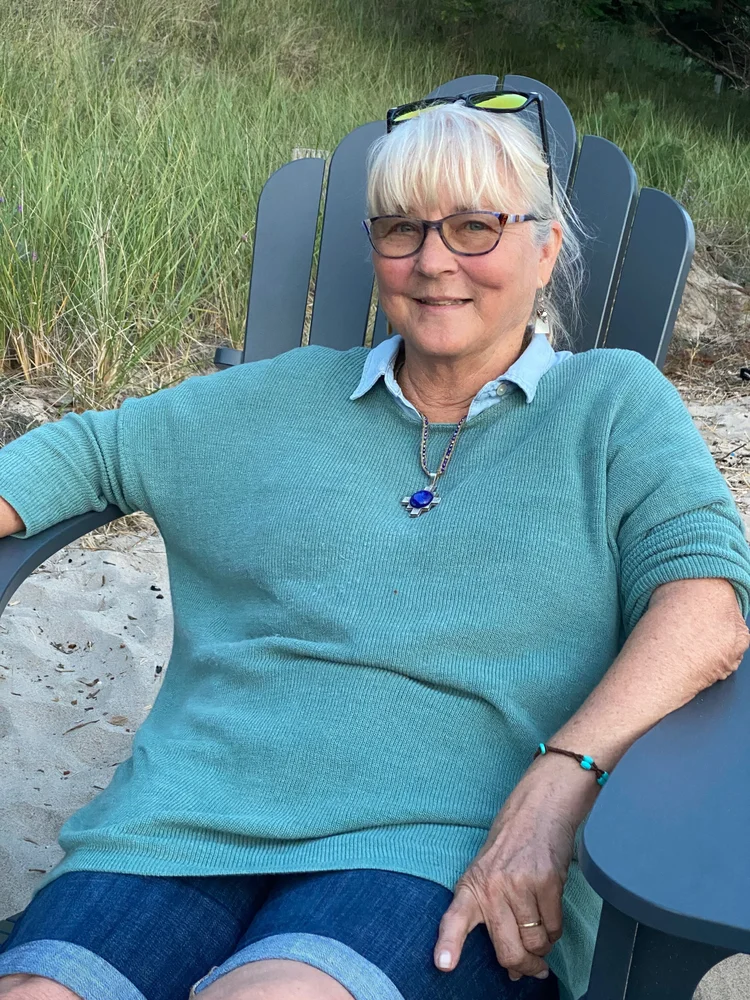 Susan Schemper seated outdoors in a blue sweater